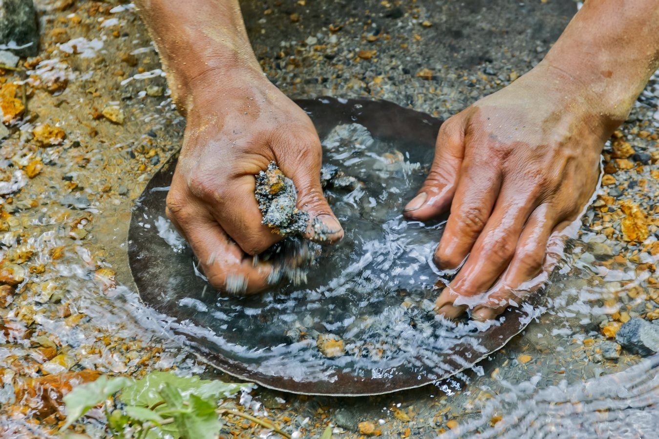 Hände waschen Gold in einem Fluss